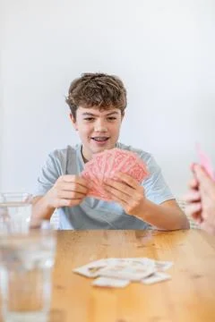 Son bonding with father playing cards at home Stock Photos