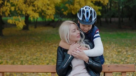 Son with broken arm cuddling his mother Stock Footage 83994970