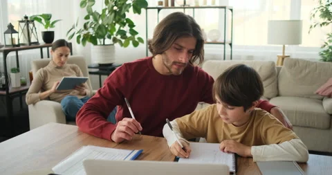 Son with father doing homework and mother using digital tablet Stock Footage 145231018