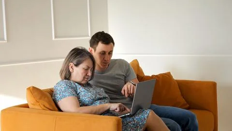 Son helping his elderly mother learn new technology and computer skills on a Stock Photos