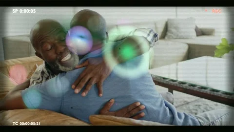 Son hugging father comforting on couch REC recording bokeh, green glitch Video stock 340674757