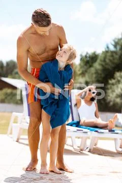 Son looking at daddy feeling thankful after swimming in pool Stock Photos