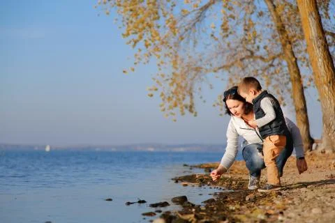 Son with mom on the beach looking for shells Stock Photos