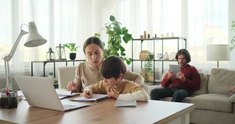 Son with mother doing homework and father using digital tablet Video stock 145230276