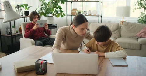 Son with mother doing homework using laptop and father using digital tablet Stock Footage 145230866