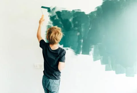 Son painting wall with roller Stock Photos