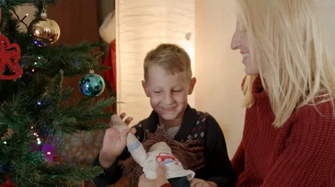 Son playing with hand made doll under christmas tree 스톡 동영상 67691291