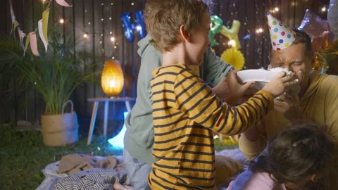 Son puts father face into cake celebrating birthday Stock Footage 163041316