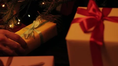 Son puts a gift under the christmas tree. Beautiful presents under the Christmas Video stock 142138838