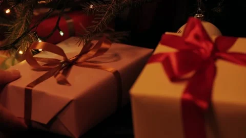 Son puts a gift under the christmas tree. Beautiful presents under the Christmas 動画素材 142138841