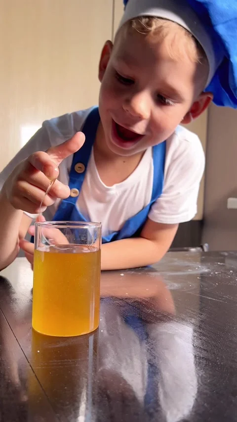 Son is tasting honey from a jar while mother is not watching. Small is helpin Stock Footage 295192487