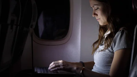 Сoncentrated woman work on laptop computer at airliner Stock Footage 98637091