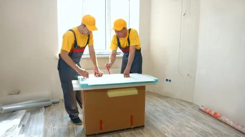 Сonfident builders looking at building plan at construction site. Stock Photos