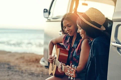 The song that would always remind them of that summer. a young woman playing a Stock Photos