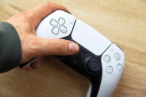 Sony PS5 Wireless Controller,on an oak wooden table,PlayStation is video gaming Stock Photos