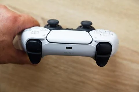 Sony PS5 Wireless Controller,on an oak wooden table,PlayStation is video gaming Stock Photos