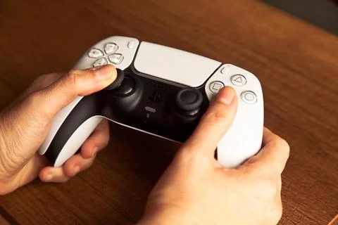 Sony PS5 Wireless Controller,on an oak wooden table,PlayStation is video gaming Stock Photos