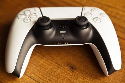 Sony PS5 Wireless Controller,on an oak wooden table,PlayStation is video gaming Stock Photos
