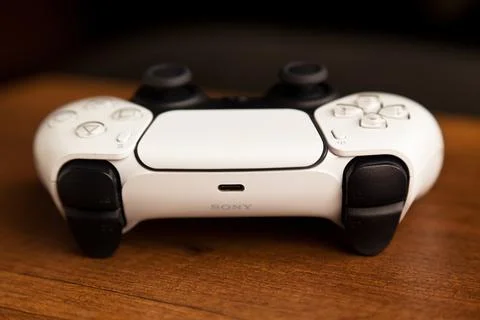 Sony PS5 Wireless Controller,on an oak wooden table,PlayStation is video gaming Stock Photos