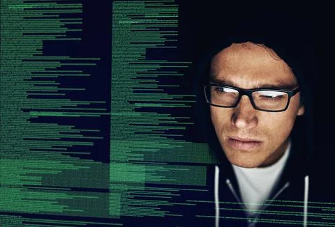 Soon all your information will be mine. a young hacker cracking a computer code 스톡 사진