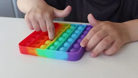 Soothing rainbow-colored Simple Dimple toy on a white background. Video stock 154906044