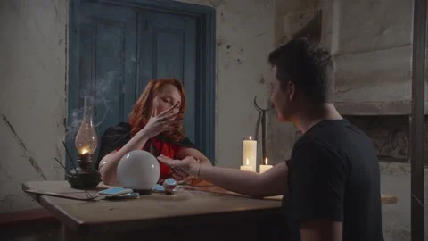 Soothsayer palm reading to man in rustic house 스톡 동영상 141115849
