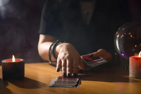 Soothsayer predicting future with cards at table indoors, closeup Stock Photos