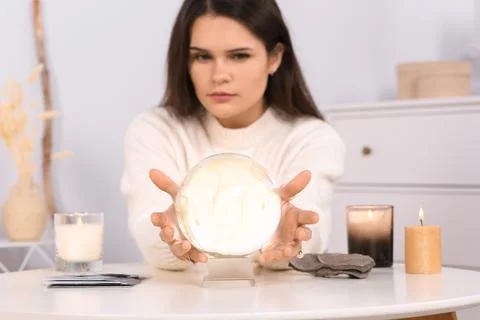 Soothsayer predicting future at table in room, focus on crystal ball 스톡 사진