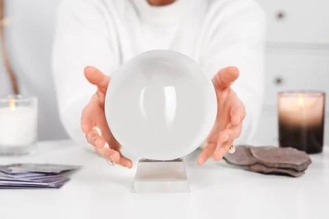 Soothsayer using crystal ball to predict future at table indoors, closeup 스톡 사진