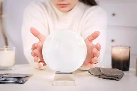 Soothsayer using crystal ball to predict future at table indoors, closeup Foto stock