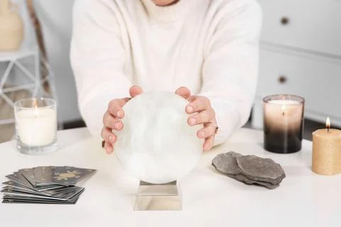 Soothsayer using crystal ball to predict future at table indoors, closeup Stock Photos