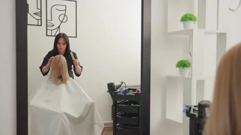 Sophisticated makeover reflected in modern salon setting and precise styling Stock Footage 333649087
