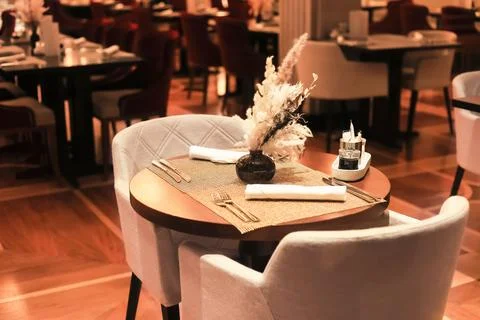 A sophisticated restaurant interior with an intimate table setting, plush c.. Foto stock