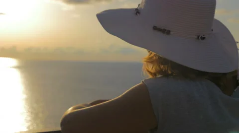  sophisticated woman with white hat contemplates the sunset Stock Footage