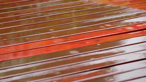 Soporific weather scene as raindrops fall on wooden deck making tiny splashes Stock Footage 333360946