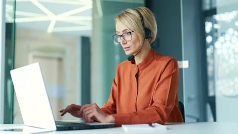 Сorporate operator who works in the support service speaks on a video call using Stock Footage 239027309