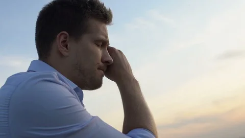 Sorrowful man thinking about problems in his life on background of evening sky Video stock 117194853