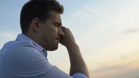 Sorrowful man thinking about problems in his life on background of evening sky Stock-Footage 117196269