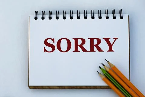 SORRY - words on a white sheet of notebook and pencils Stock Photos