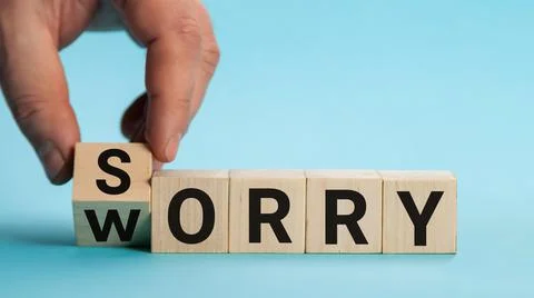 Sorry to worry. Hand turns a cube and changes the word worry to sorry. Business Stock Photos