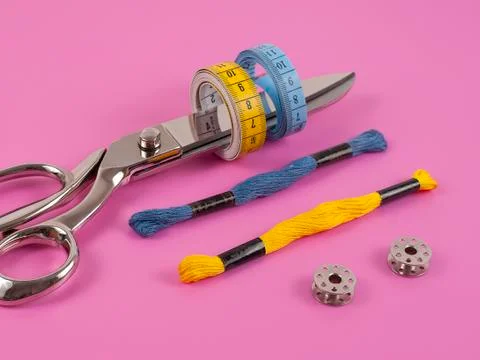 Sors and spools of thread on pink background Stock Photos