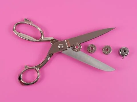 Sors and spools of thread on pink background Stock Photos