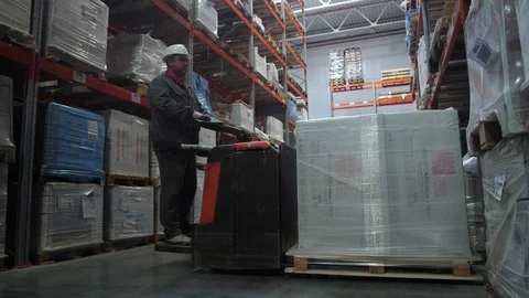 Sort goods in a logistic warehouse. The worker puts the pallets with boxes. 4K 库存影片 111767038