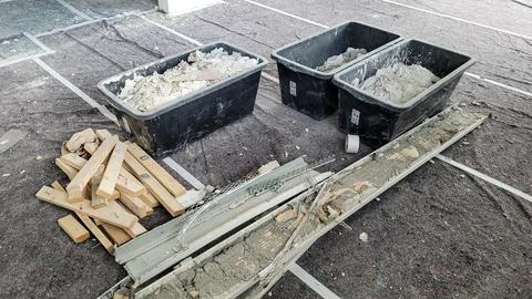 Sorted construction garbage on a protected floor in the middle of the room Stock Photos