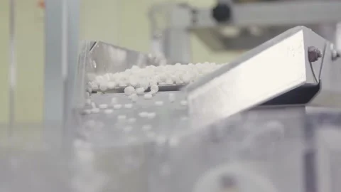 Sorted pile of pills are dropping into automated packing equipment. drug Video stock 200856558