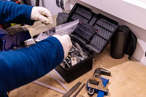Sorting and Selecting Metal Fasteners and Parts from Toolbox in Workshop 스톡 사진