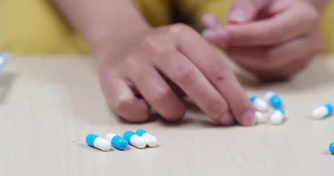 Sorting blue and white capsules home tutorial indoor close-up health awareness Vídeos de archivo 334581979
