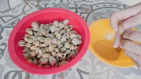 Sorting freshly harvested almonds, removing hulls from one bowl to another on Stock Footage 346152190