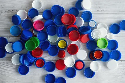 Sorting household colored plastic bottle caps and lids captured from above, flat Stock Photos