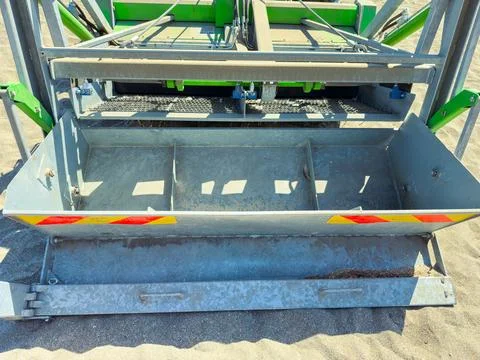 A sorting machine stands on a sandy surface at a construction site. It has mu Stock Photos